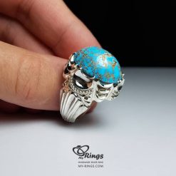 The Neyshabur turquoise ring held in the hand, showing the scale of the stone