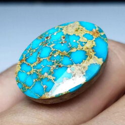 Angled view of the Nishapur turquoise cabochon showing the domed polish and the depth of the golden veining